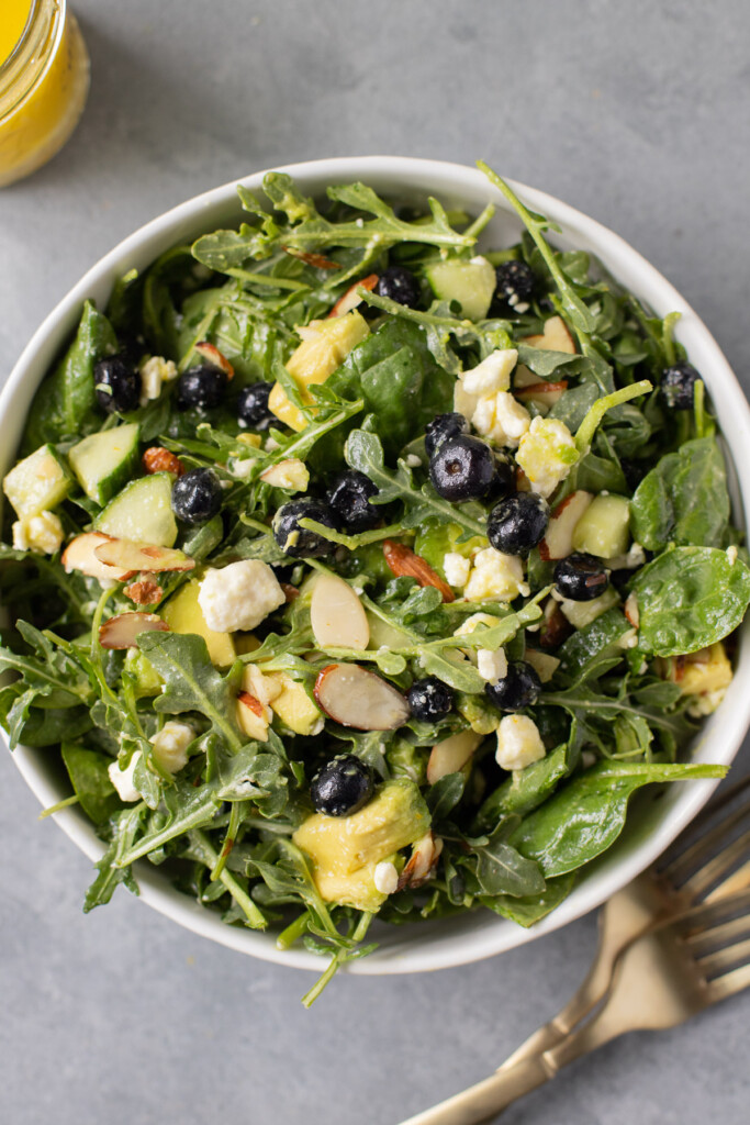 A close up of a salad covered with citrus salad dressing