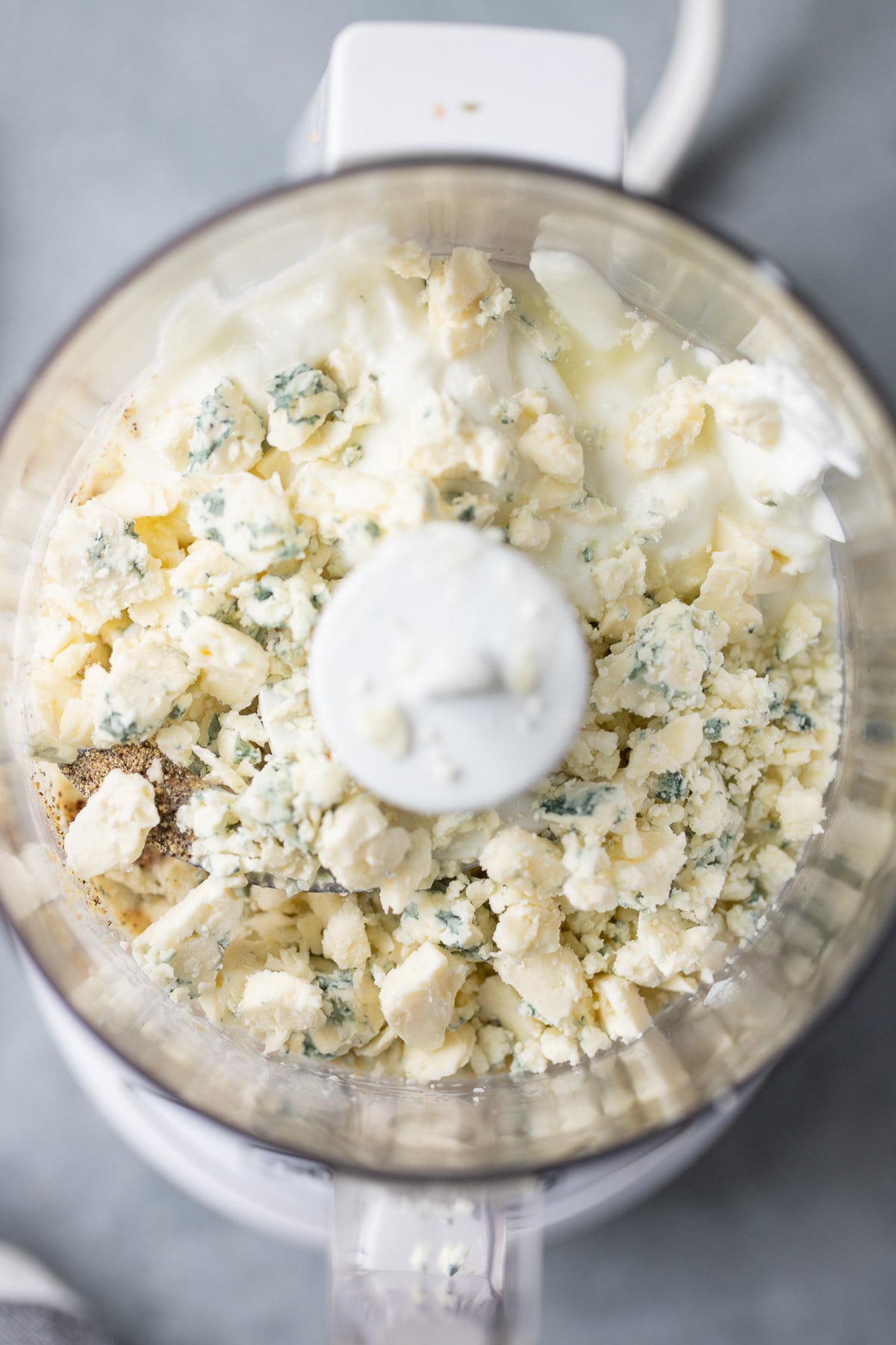 A close up of healthy blue cheese dressing in a food processor before being blended
