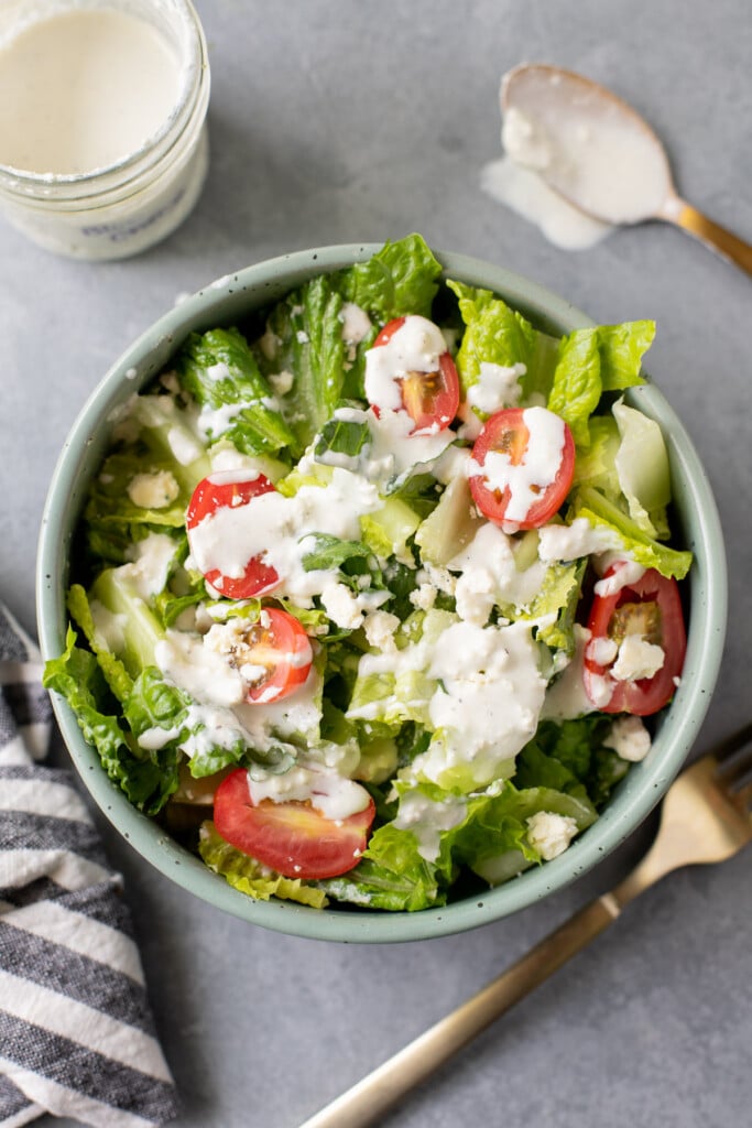 healthy blue cheese dressing on top of a salad in a green bowl