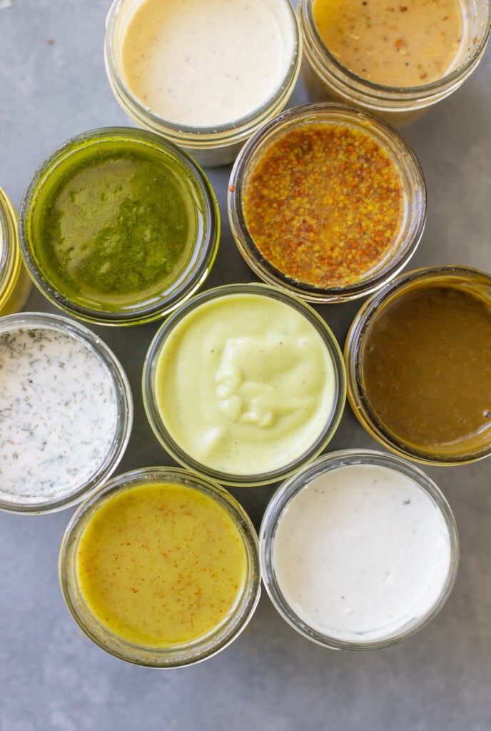 A close up of ealthy salad dressings homemade in mason jars