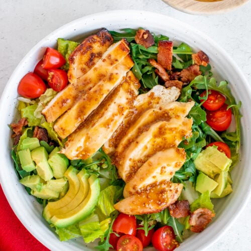 A close up of honey mustard dressing drizzled on a salad