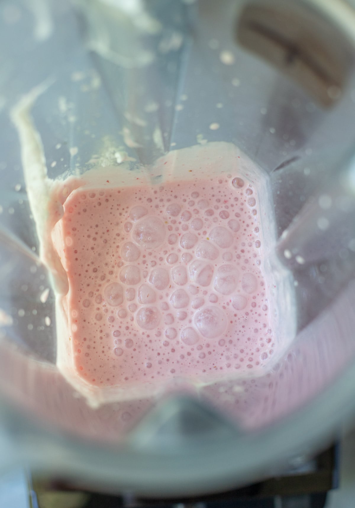 An overhead shot of strawberry smoothie in a blender after blending