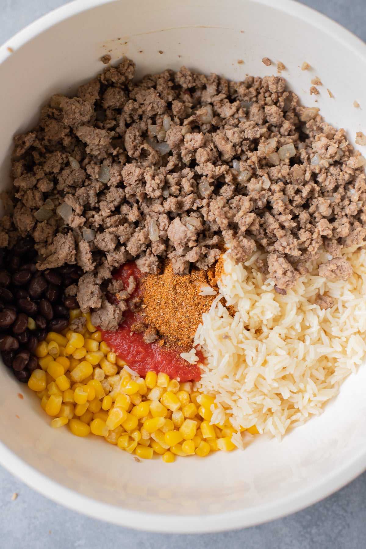 Ingredients for taco stuffed pepper filling in a white bowl before being mixed