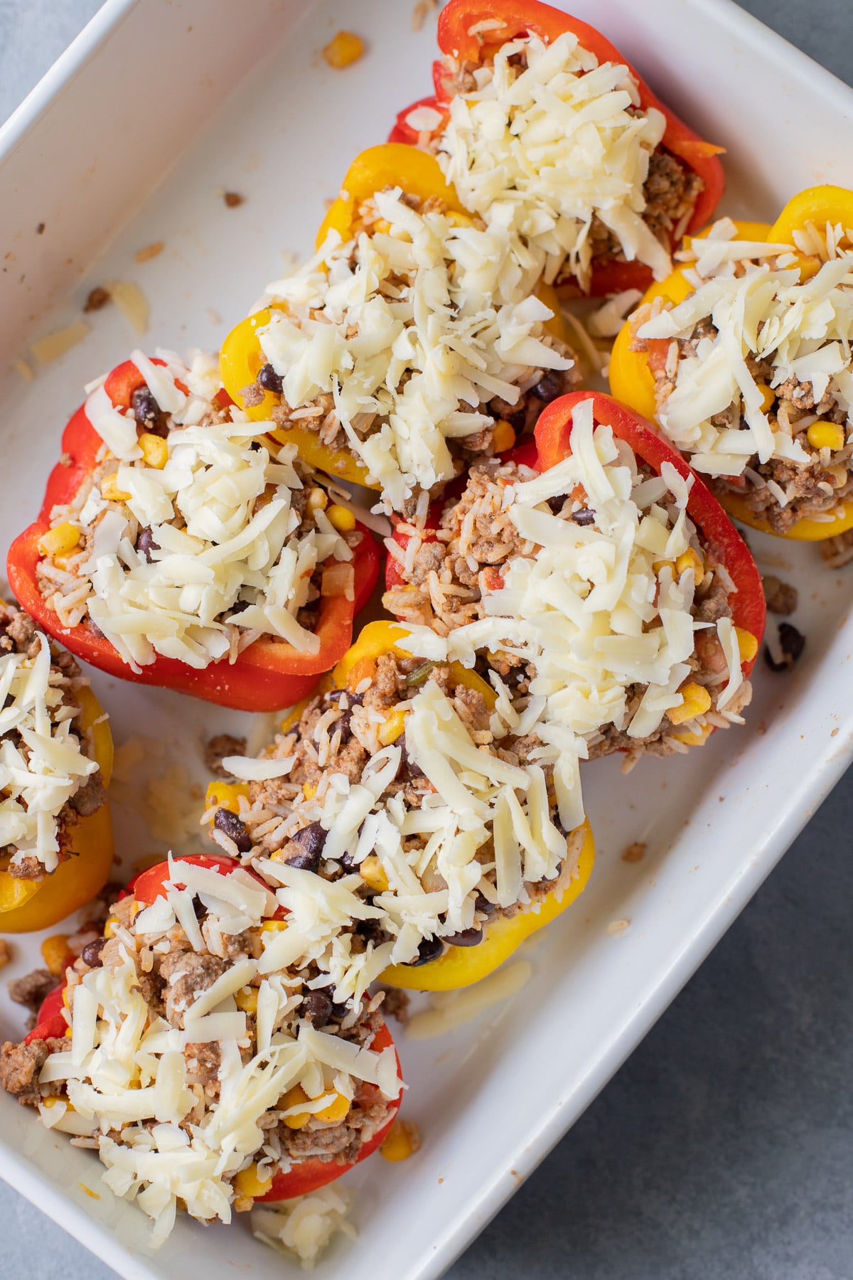 taco stuffed peppers in a white baking dish before being cooked