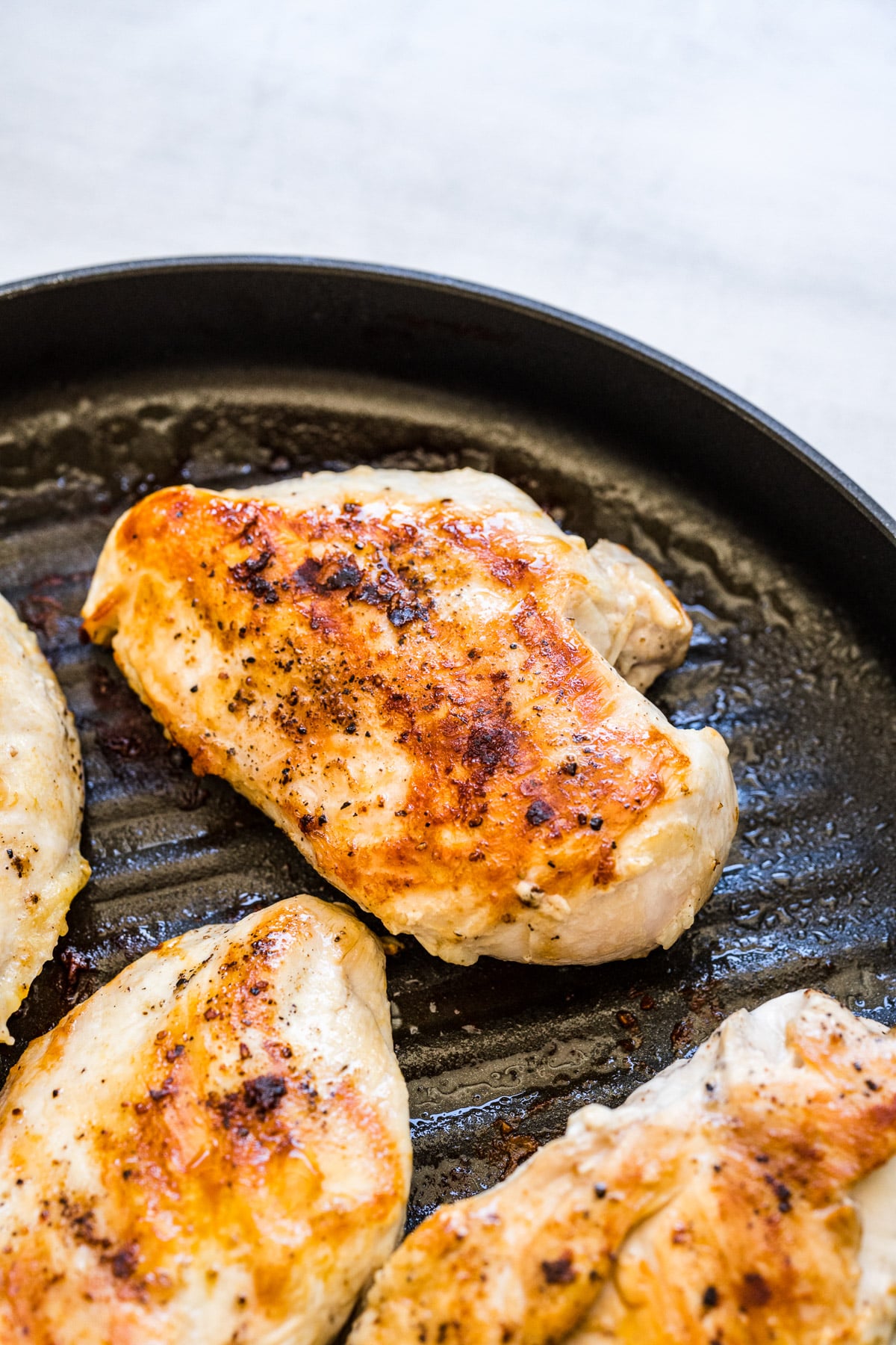 A chicken breast on a grill pan after cooking for greek chicken pasta salad