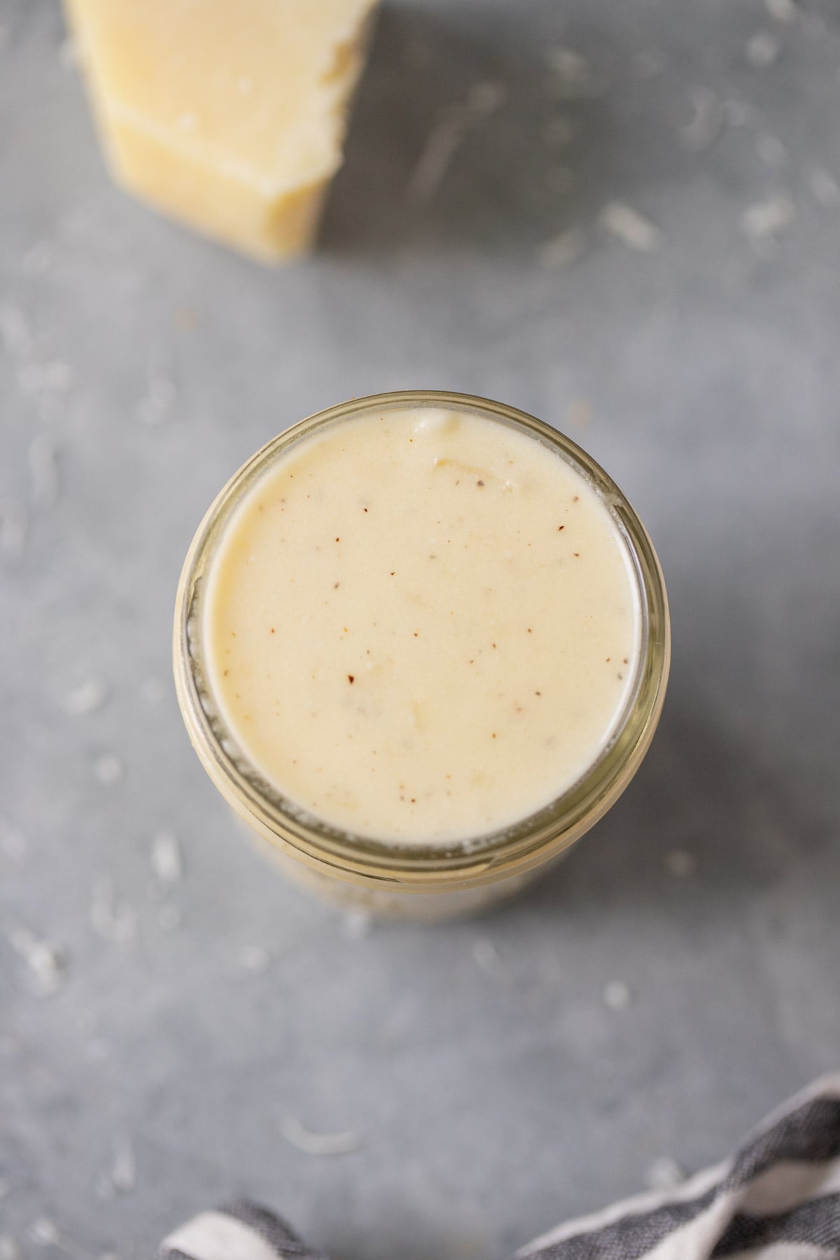 a jar of low fat alfredo sauce on a grey background
