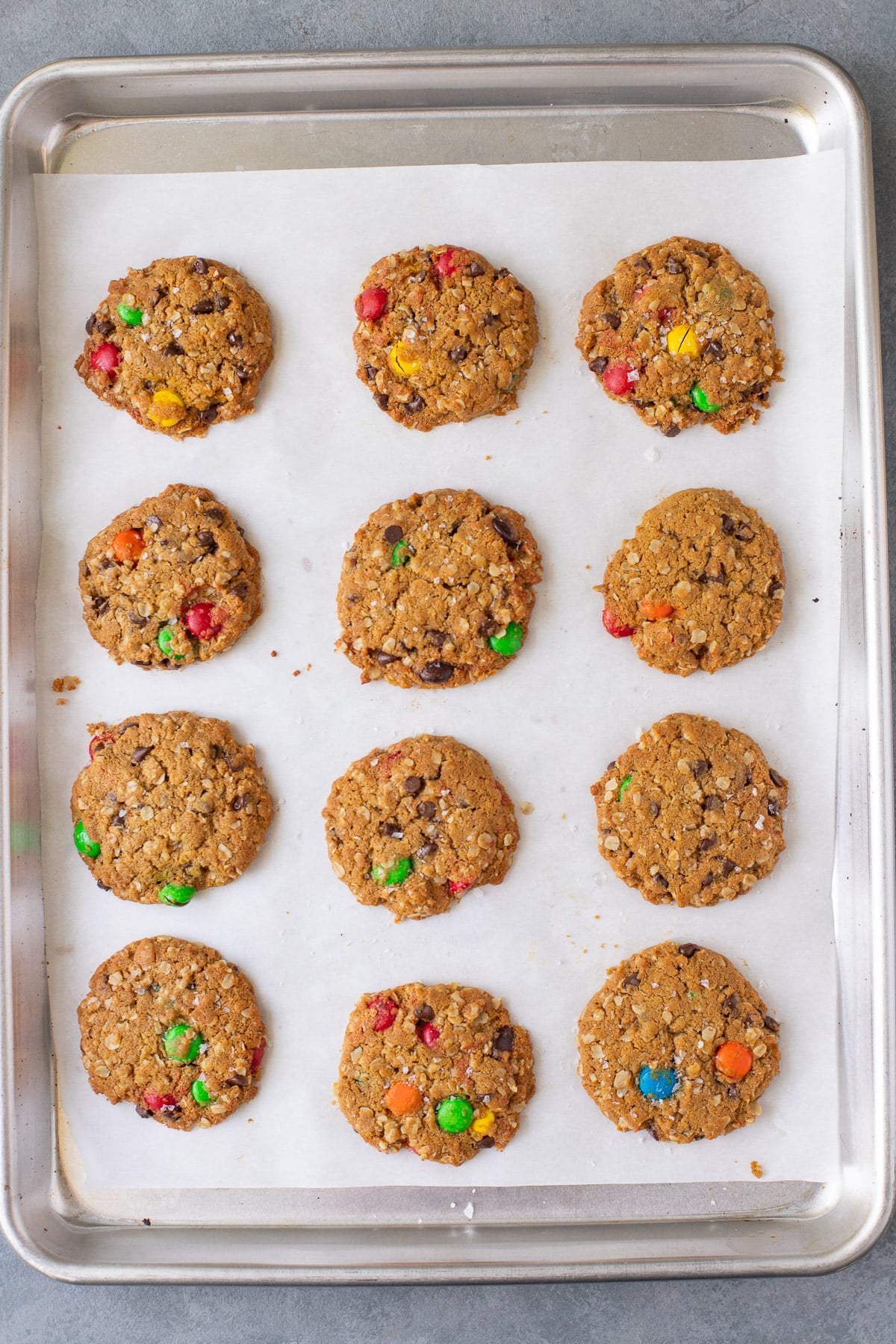 Healthy Monster Cookies on a parchment lined baking sheet after baking