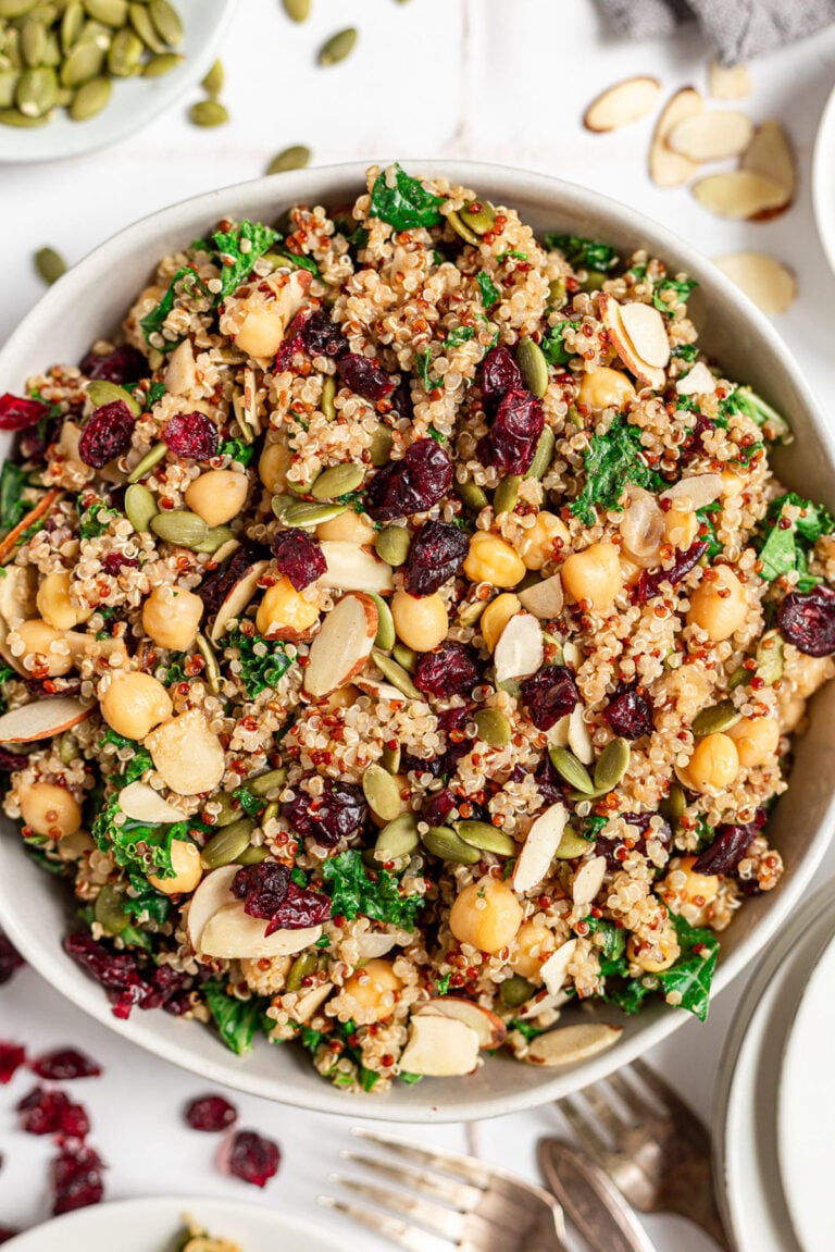 An overhead shot of a bowl of kale quinoa salad on a grey background