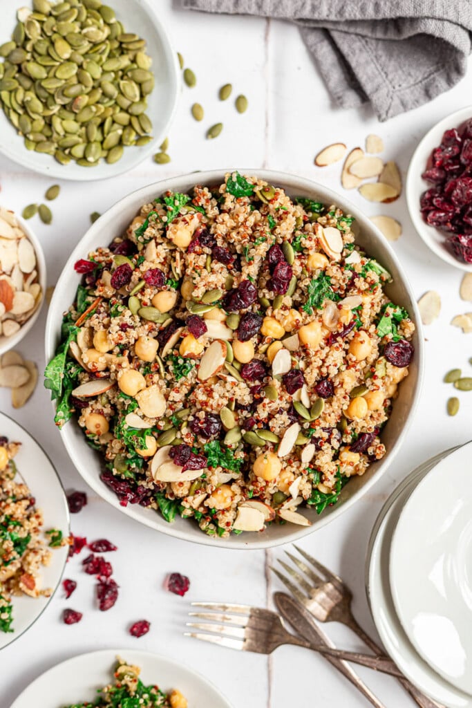 An overhead shot of a bowl of quinoa kale salad on a grey background