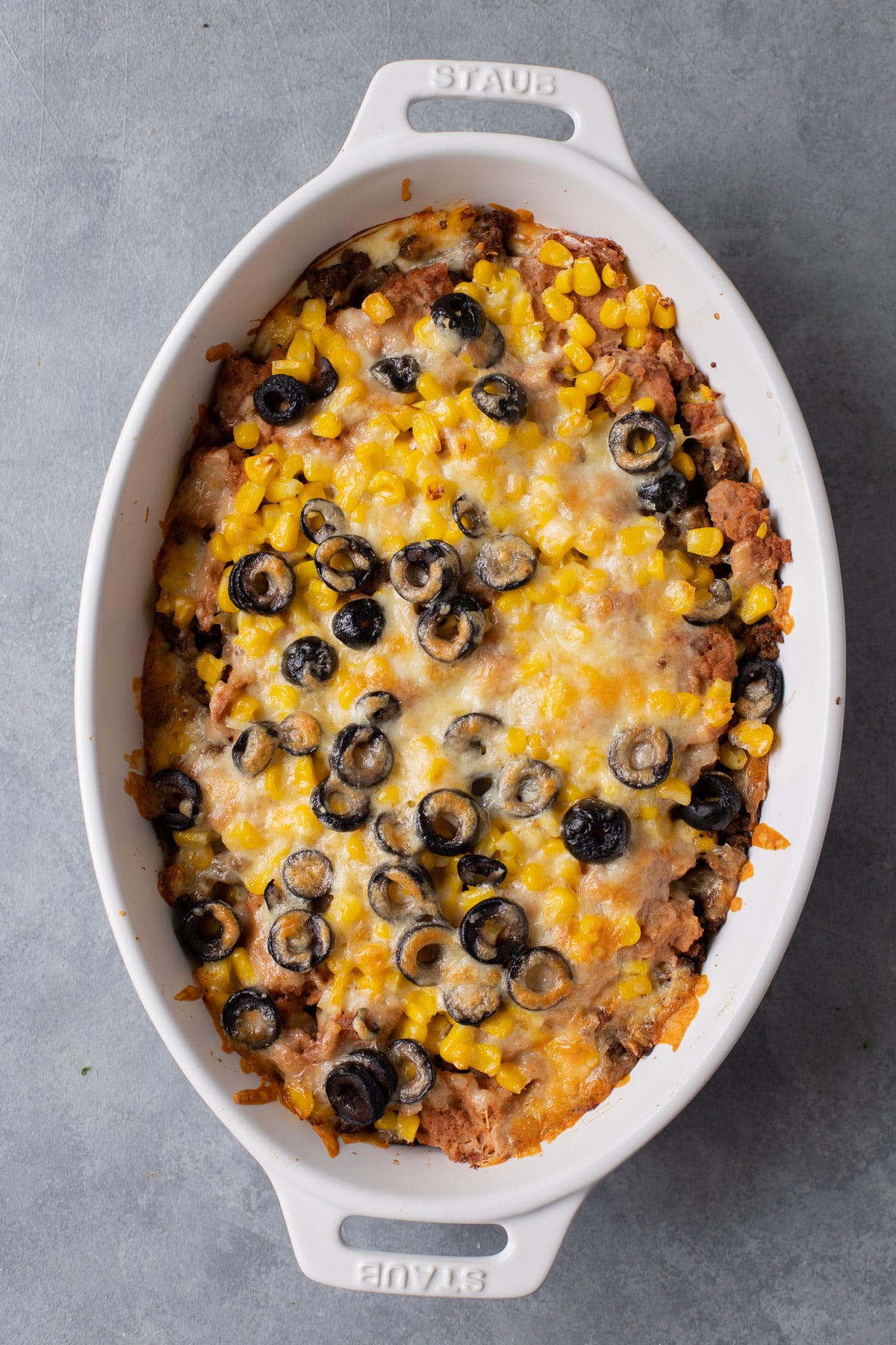 Baked seven layer dip in a white baking dish (missing the pico de gallo)