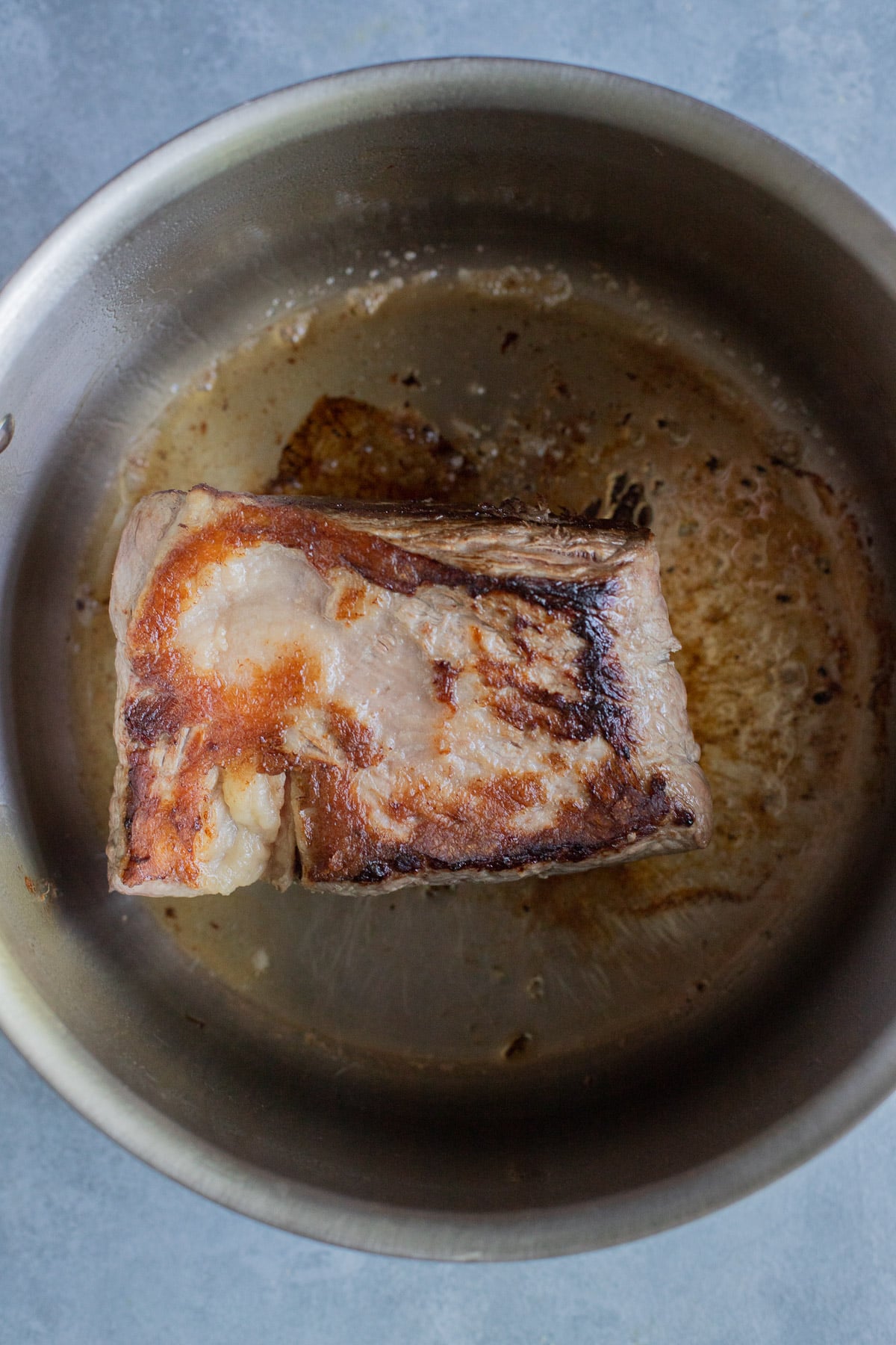 Beef roast being browned in a pot for beef soup