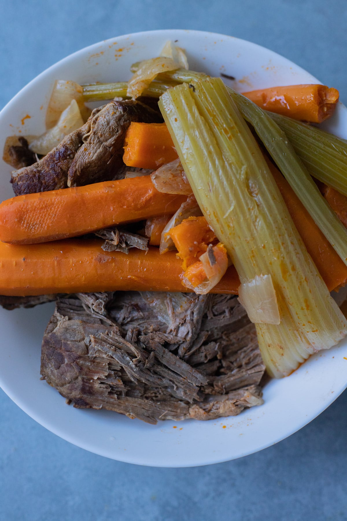 Cooked beef roast, celery, and carrots ready to be prepped and chopped for beef soup