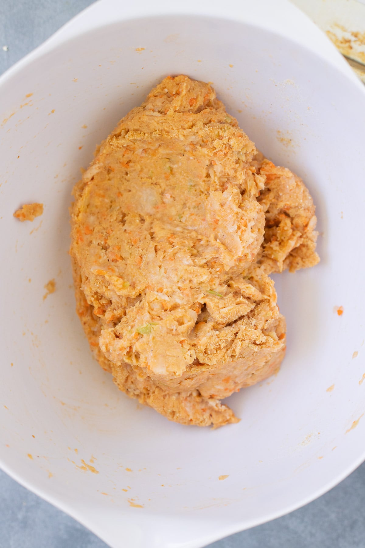 A white bowl with buffalo chicken meatball mixture after being mixed. 