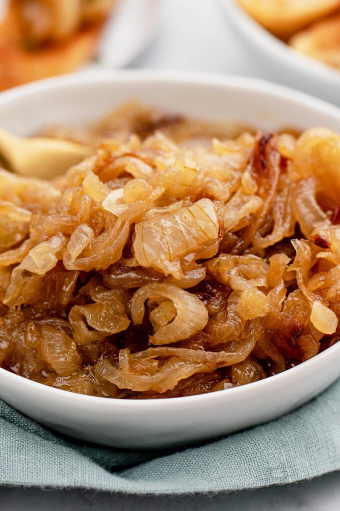 A close up of a white bowl with caramelized onions