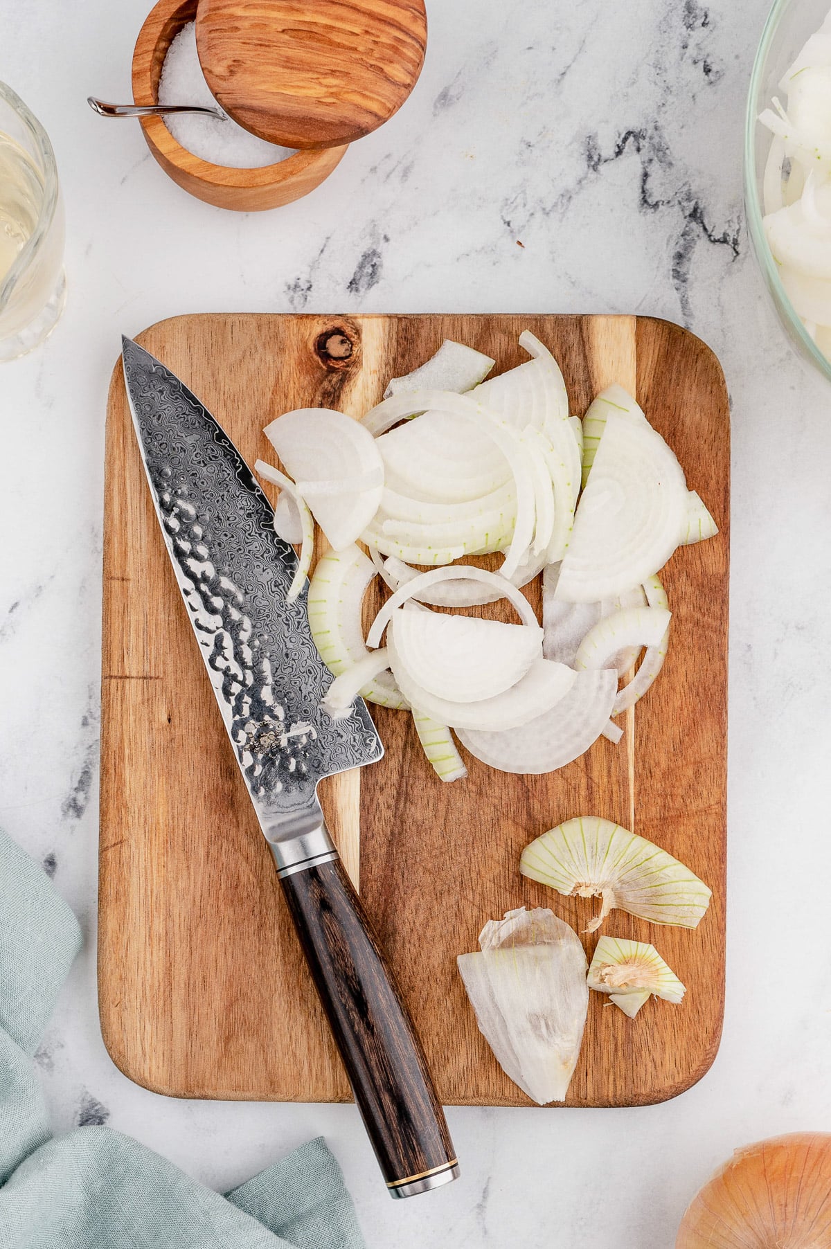 chopped onions on a cutting board with a knife for caramelized onions