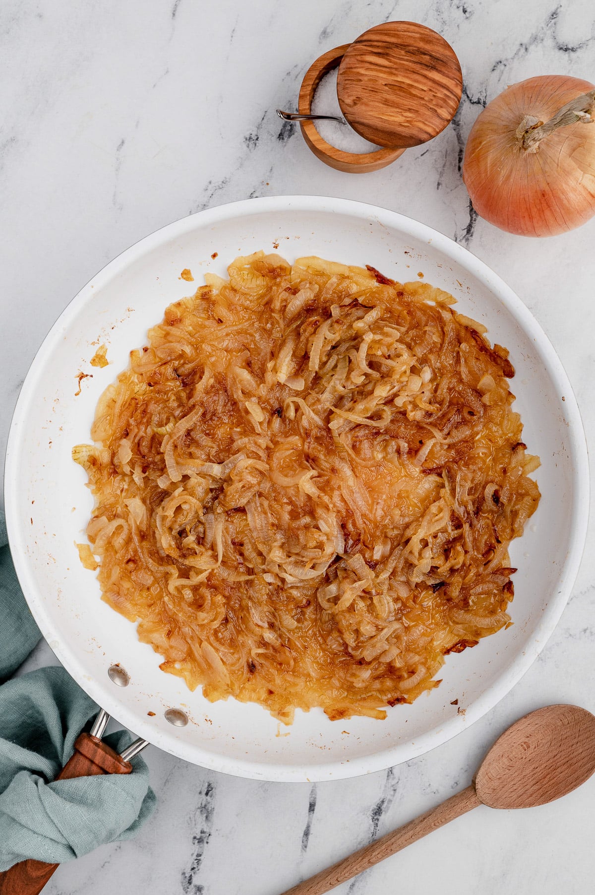 A pan with caramelized onions after cooking on a marble background