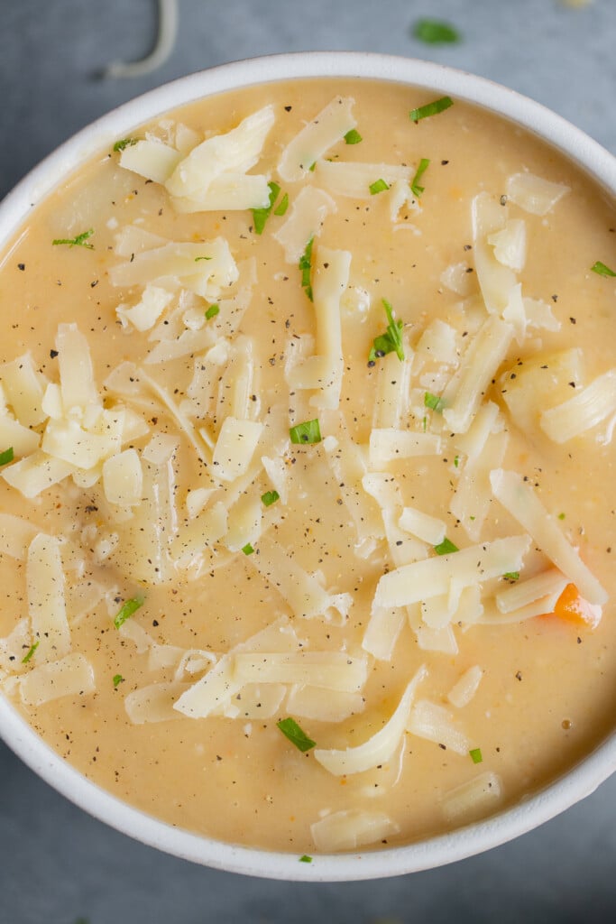 A close up of a bowl of crock pot potato soup in a white bowl