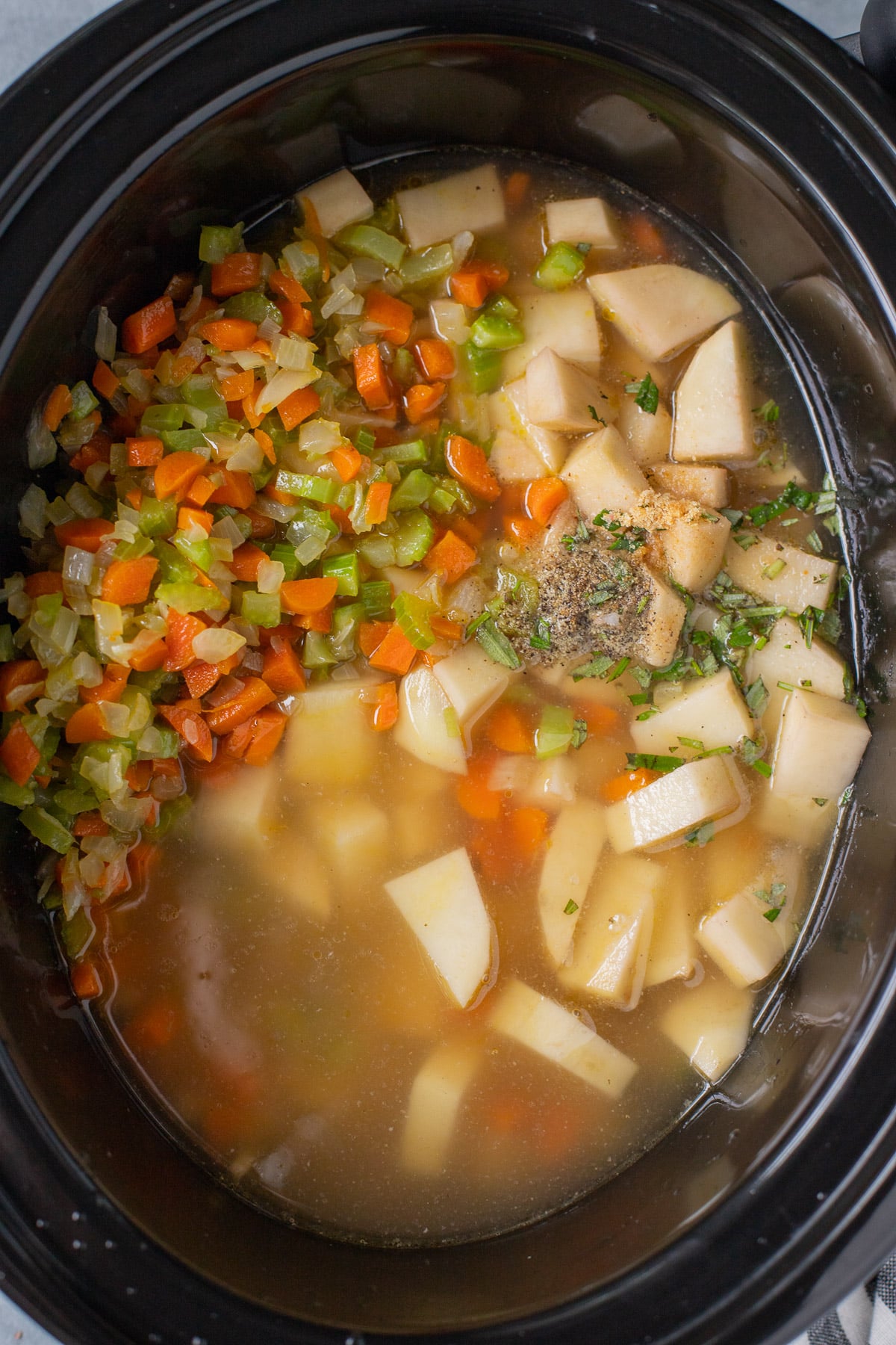 All ingredients for crock pot potato soup in a slow cooker before cooking