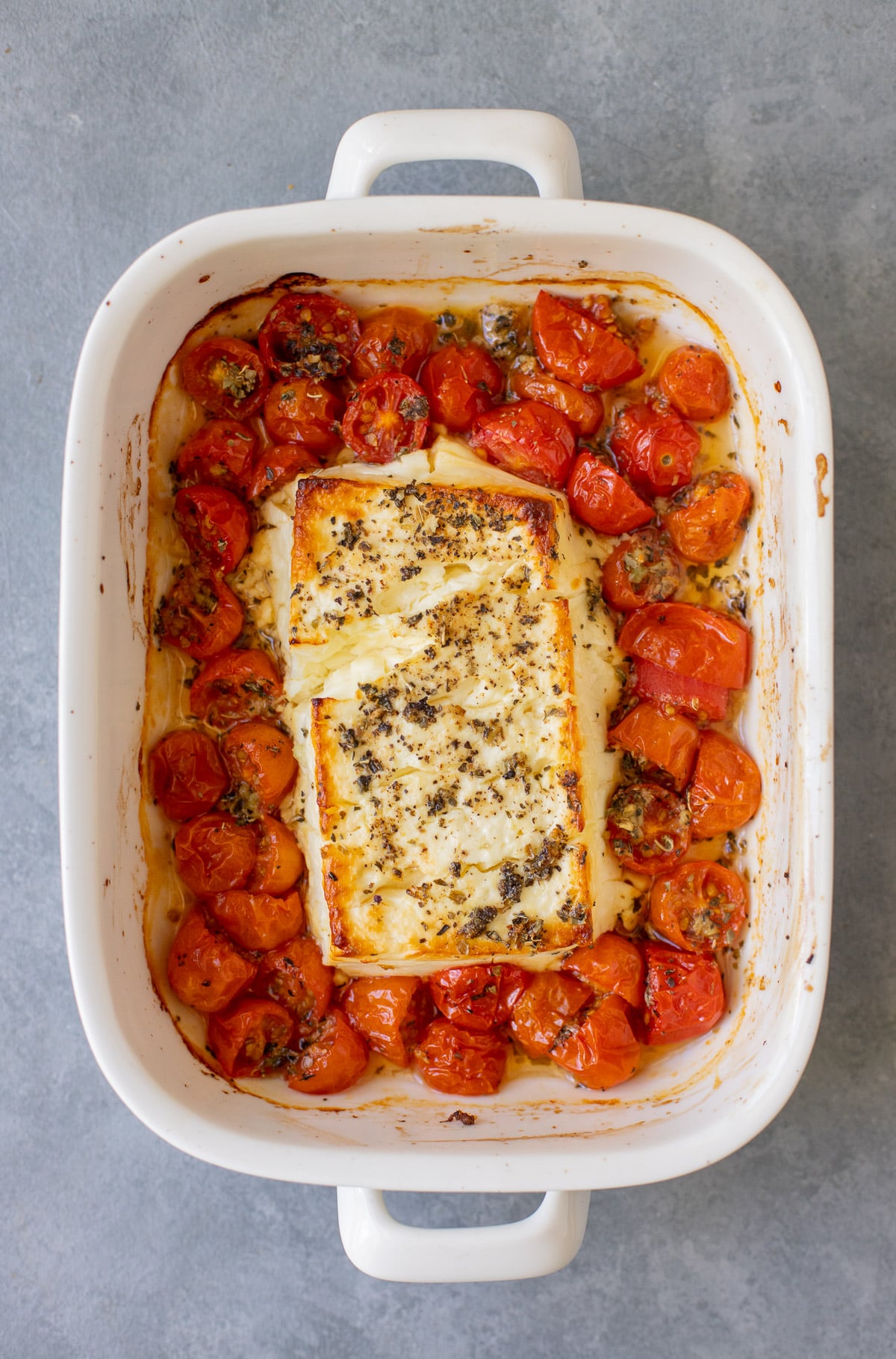An overhead shot of a baking dish with warm baked feta dip