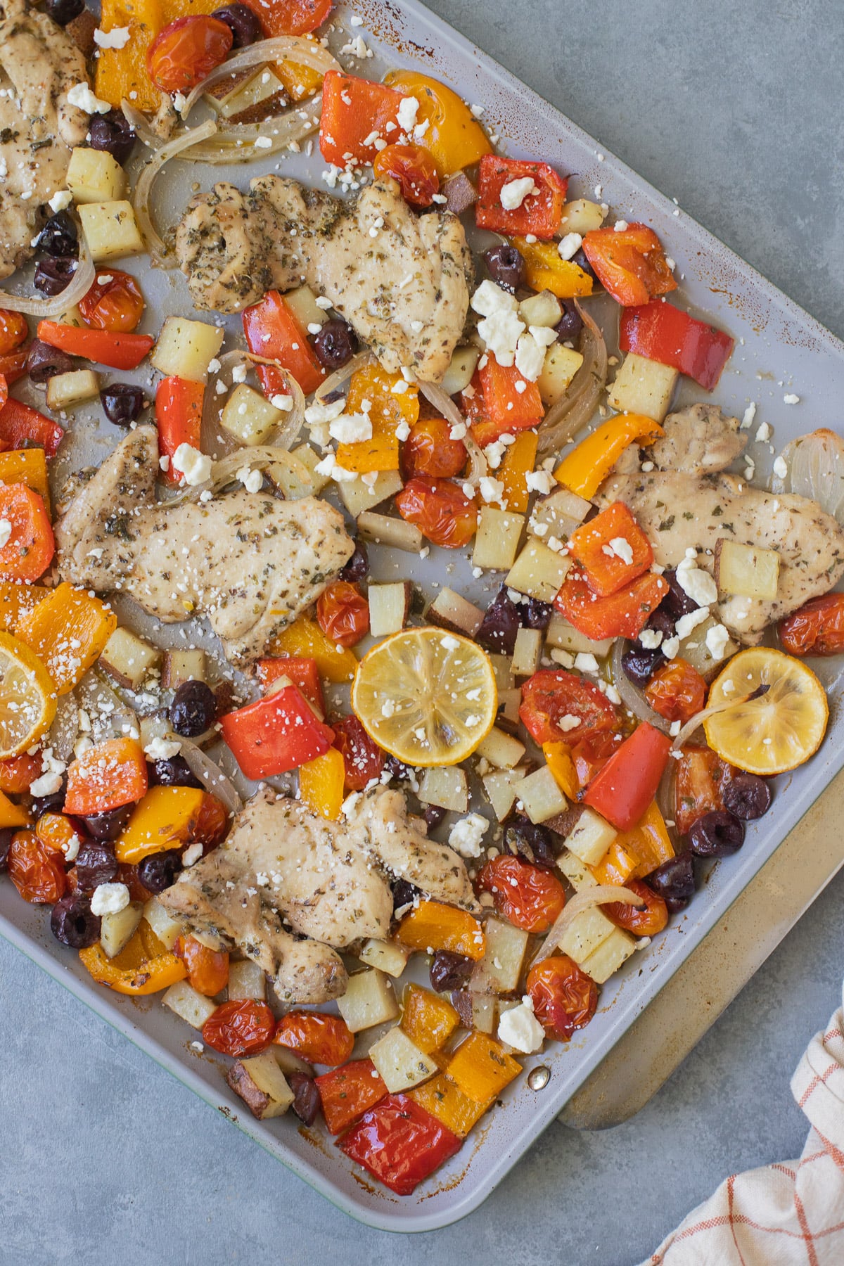 A sheet pan of greek chicken thighs after coming out of the oven