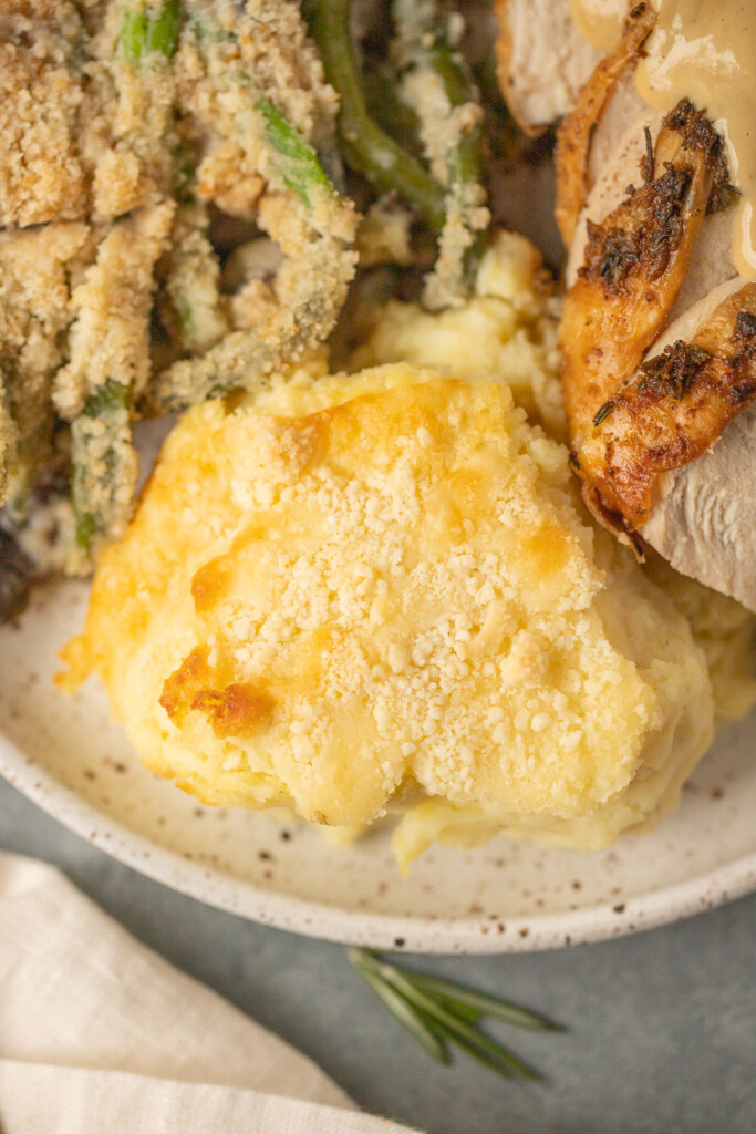 A plate with healthy mashed potatoes on it and herb butter turkey and green beans on the side