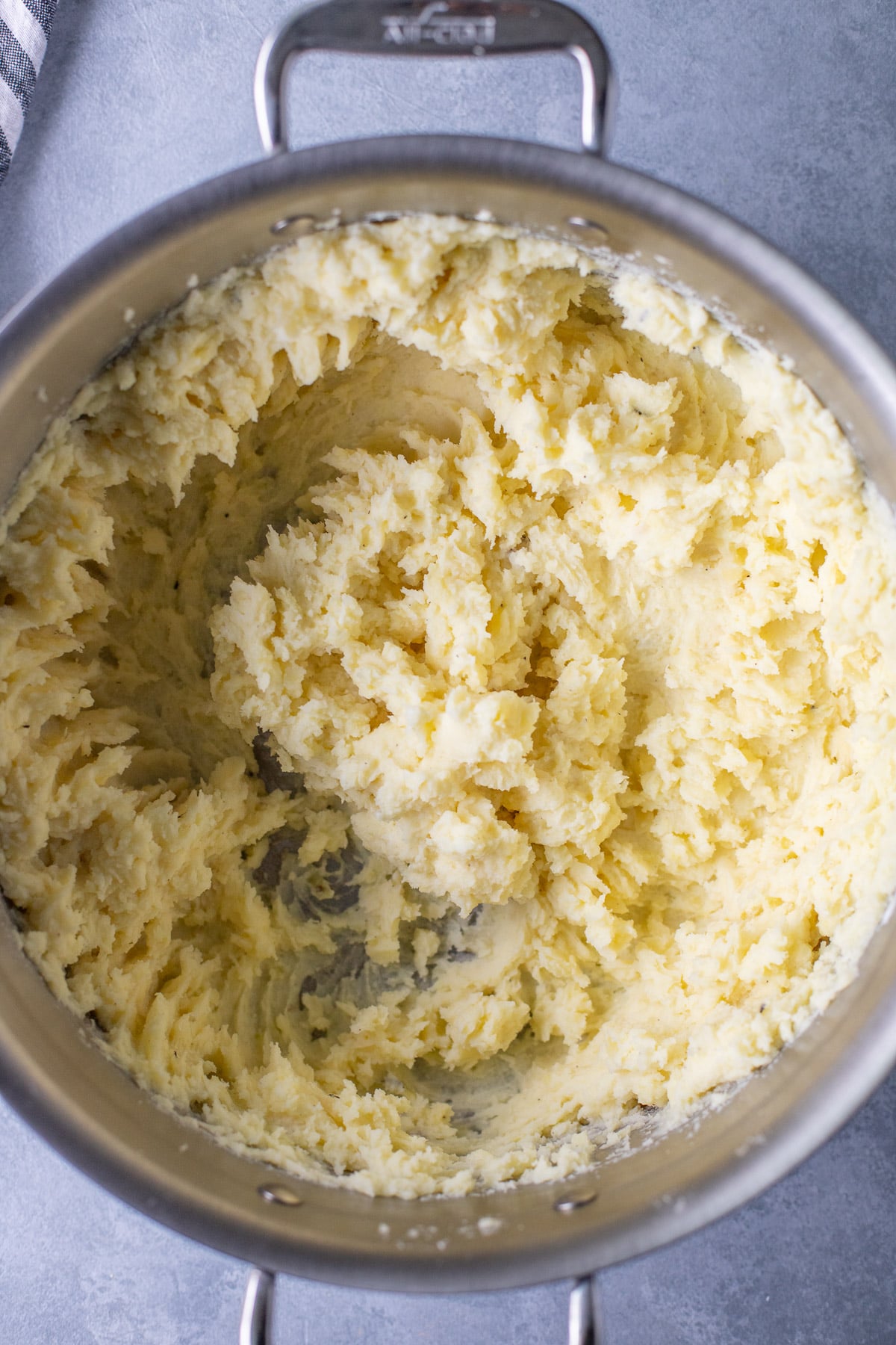 A pot of mashed potatoes on a grey background