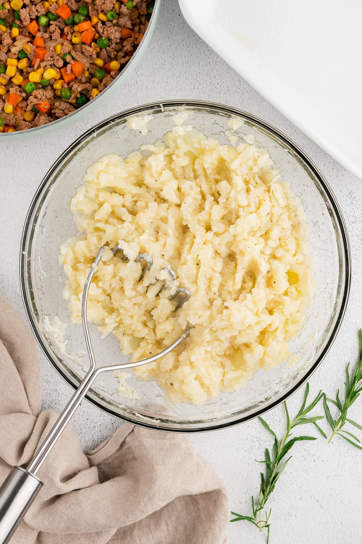 Potatoes, cauliflower being mashed for healthy shepherd's pie topping
