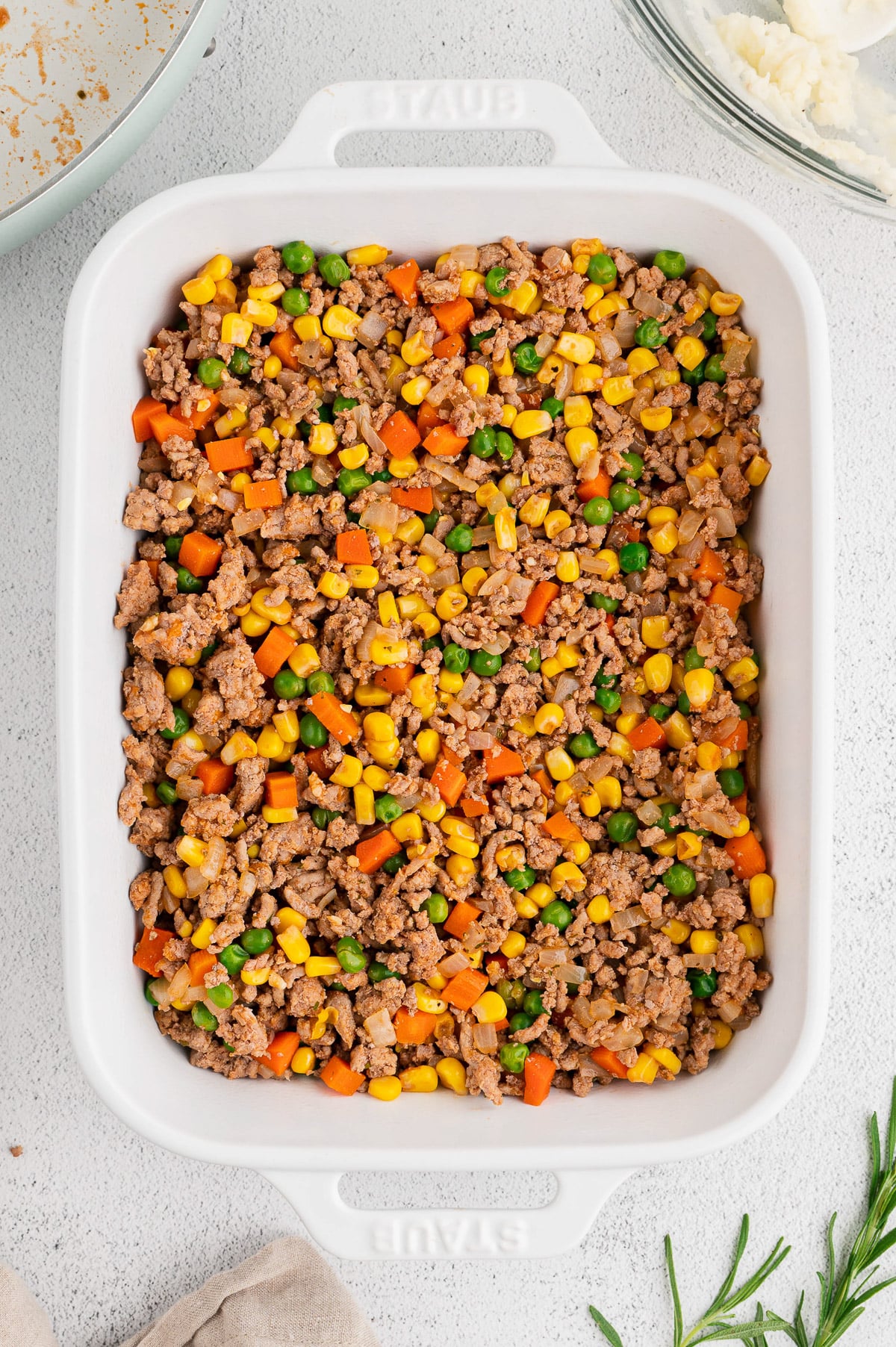 Ground turkey/veggie filling in a white baking dish for healthy shepherd's pie