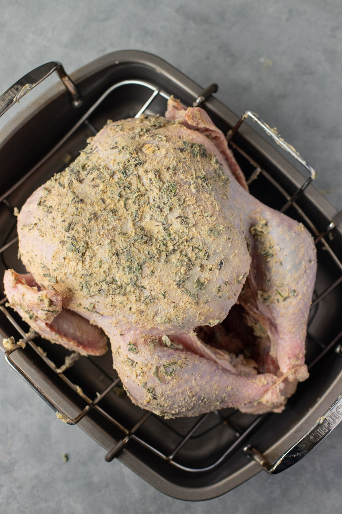 a turkey coated in herb butter before going in the oven