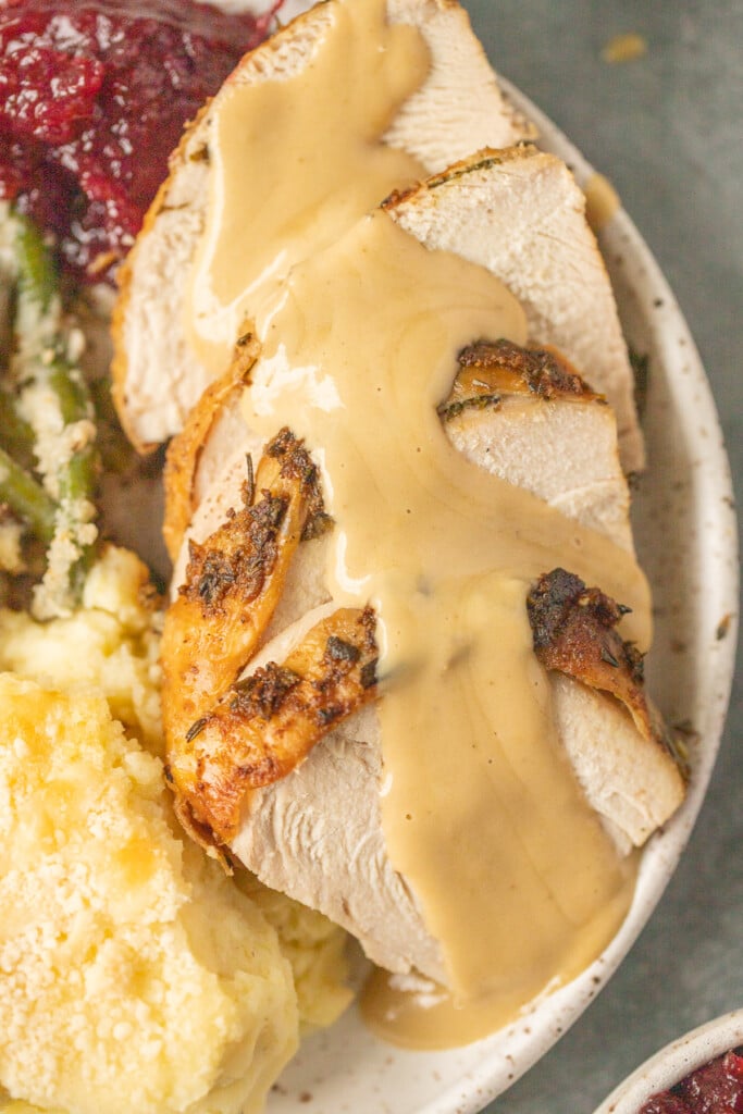 a close up of herb butter turkey on a white plate