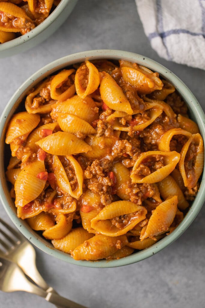 a green bowl filled to the brim with delicious taco pasta