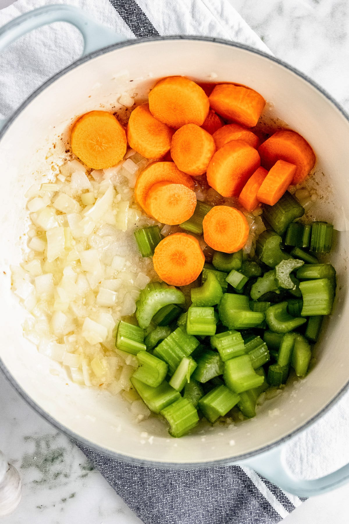 A large pot with uncooked carrots, celery, onions for turkey and wild rice soup