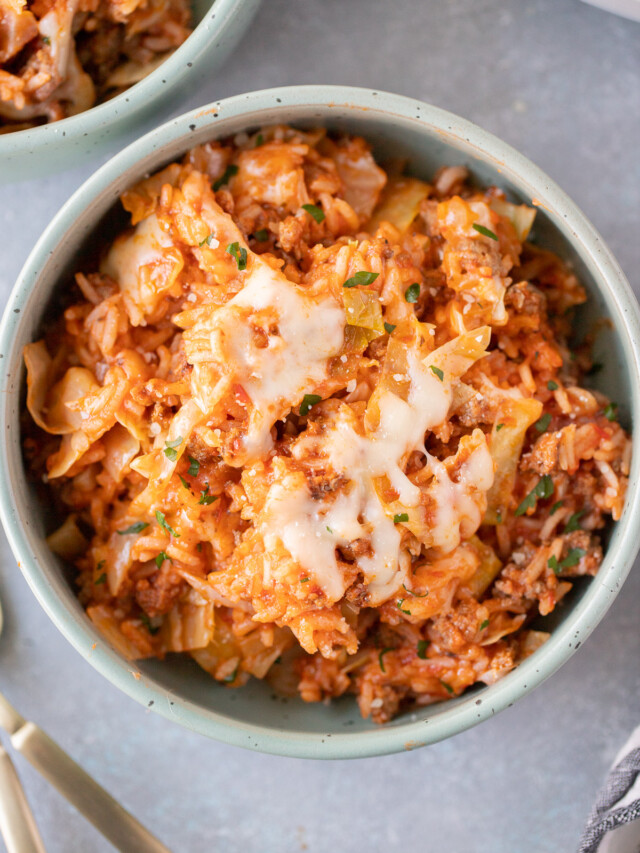 An overhead shot of an unstuffed cabbage rolls recipe in a bowl with another bowl on the side on a grey background