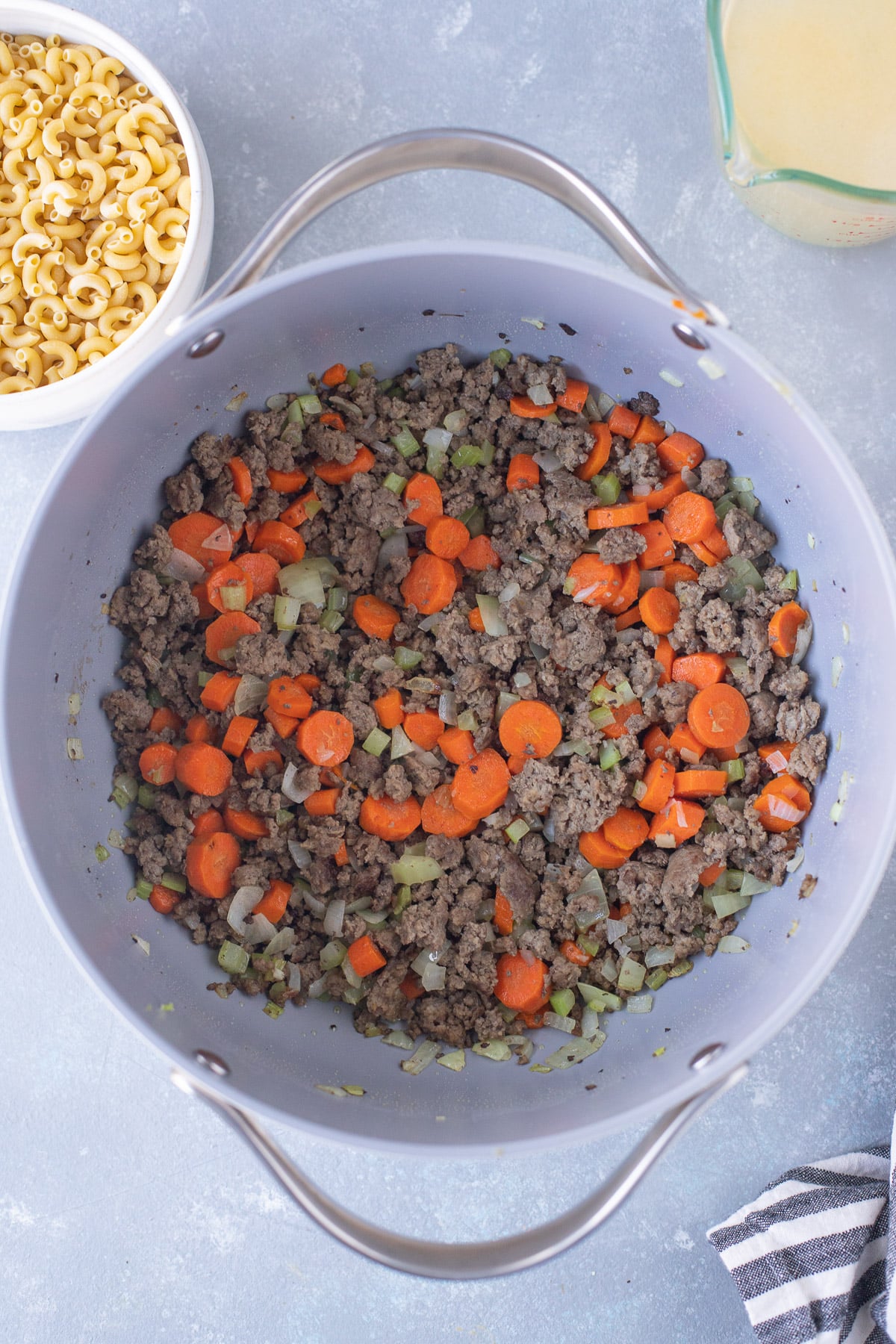 Ground beef, carrots, and celery in a pot for hamburger vegetable soup