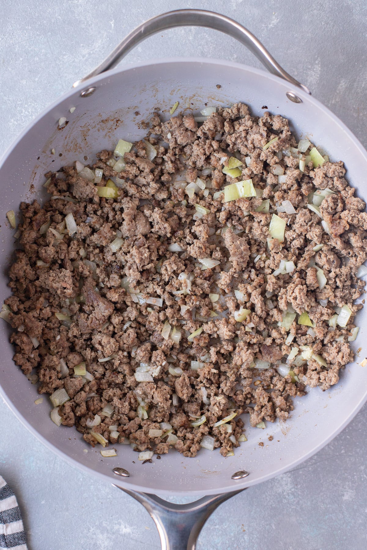 An overhead shot of ground beef, onion and garlic in a pan for unstuffed cabbage rolls
