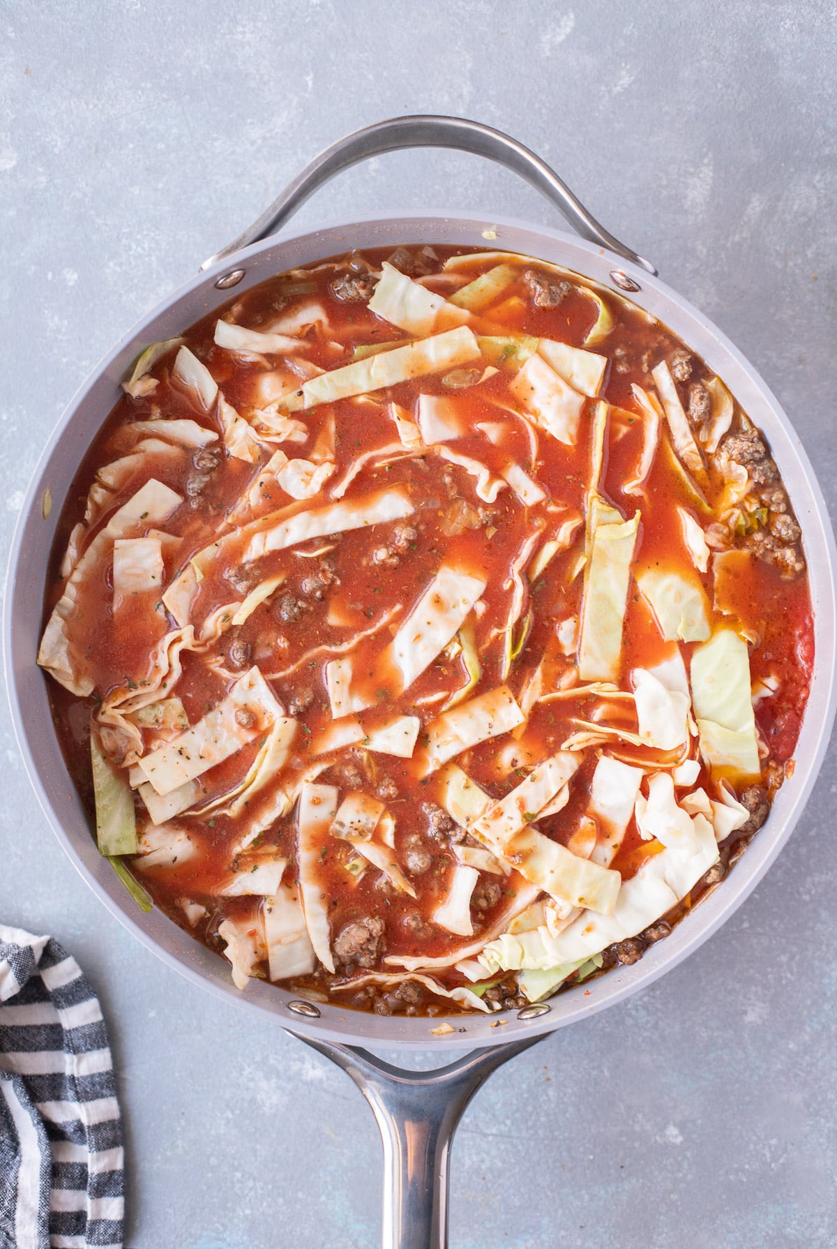 An overhead shot of unstuffed cabbage rolls in a pan before cooking