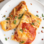 A white plate with two pieces of keto pizza with cauliflower pizza crust