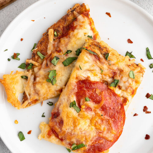 A white plate with two pieces of keto pizza with cauliflower pizza crust