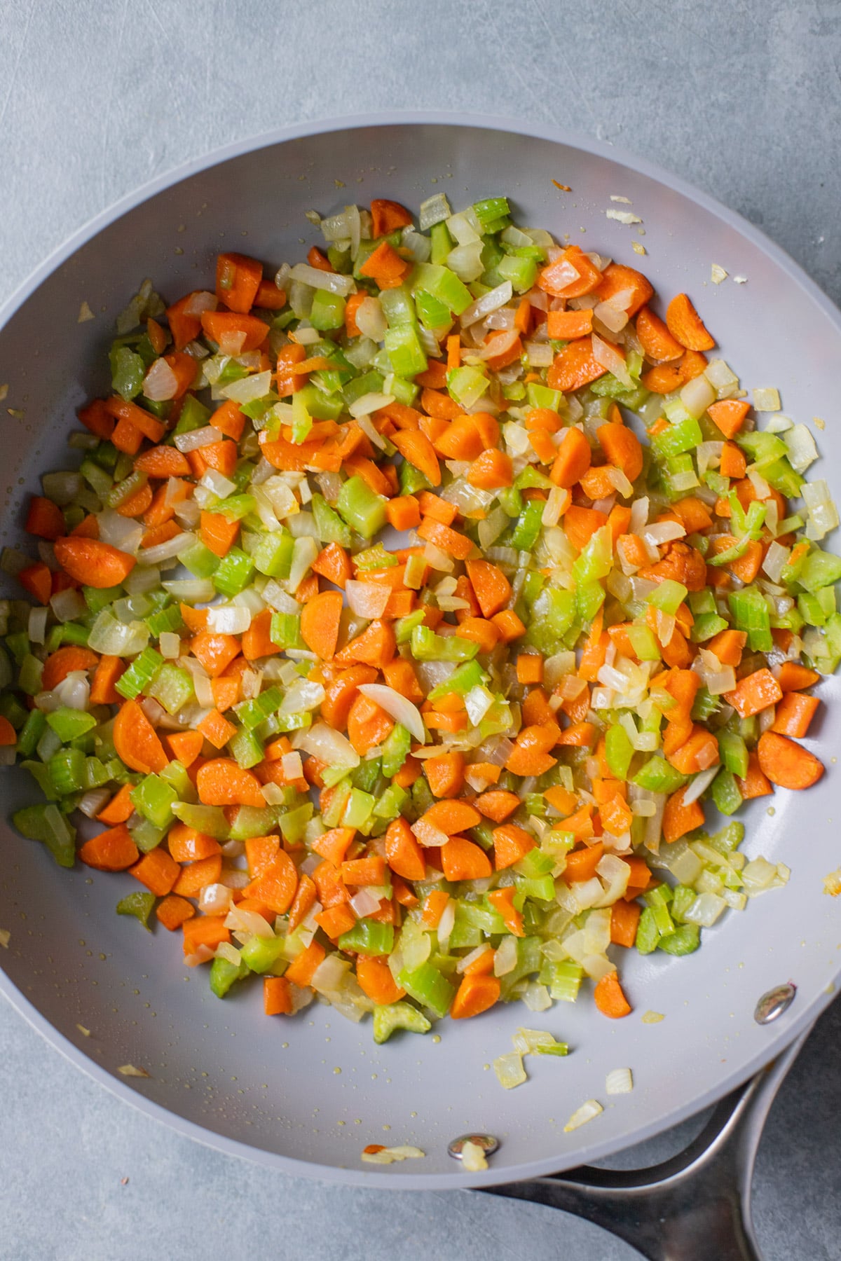 Onions, carrots, and celery after sauteing in a pan for vegetable soup