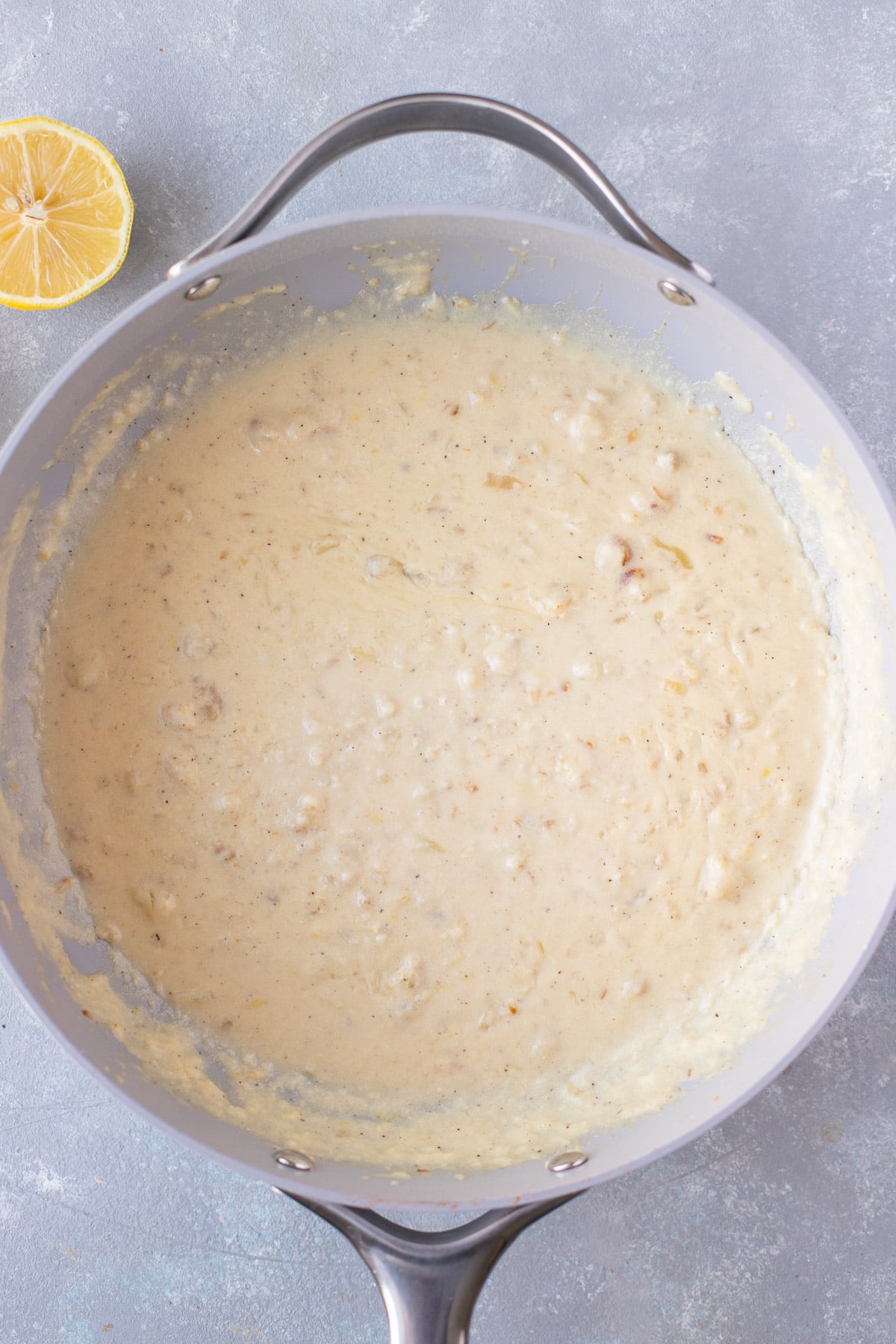 Lemon sauce in a pan on a grey background before pasta is added