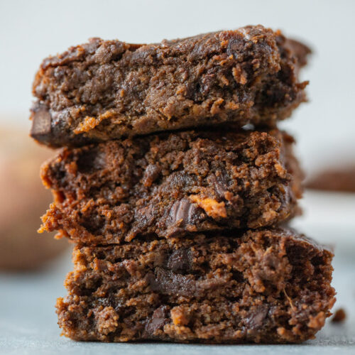 A stack of sweet potato brownies on a grey background