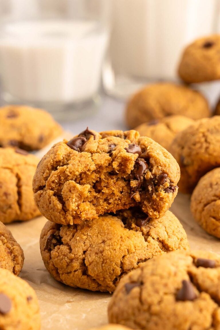 Two protein cookies stacked on top of each other. The top one has a bite taken out of it.