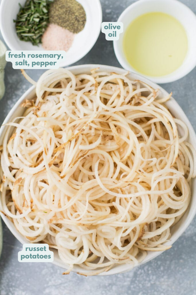 Ingredients for spiralized potatoes laid out in small white bowls on a grey background