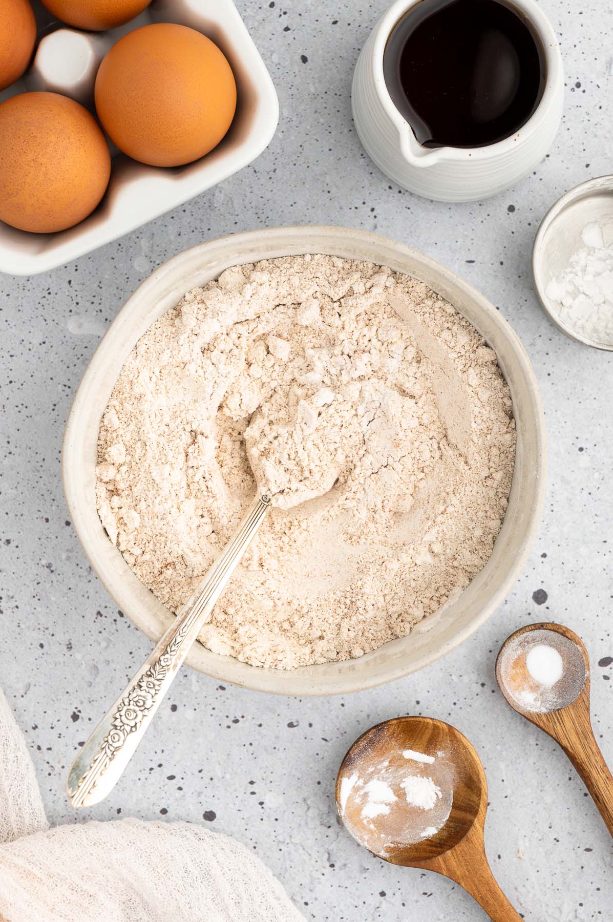 Dry ingredients mixed in a bowl for sweet potato pancakes on a grey background
