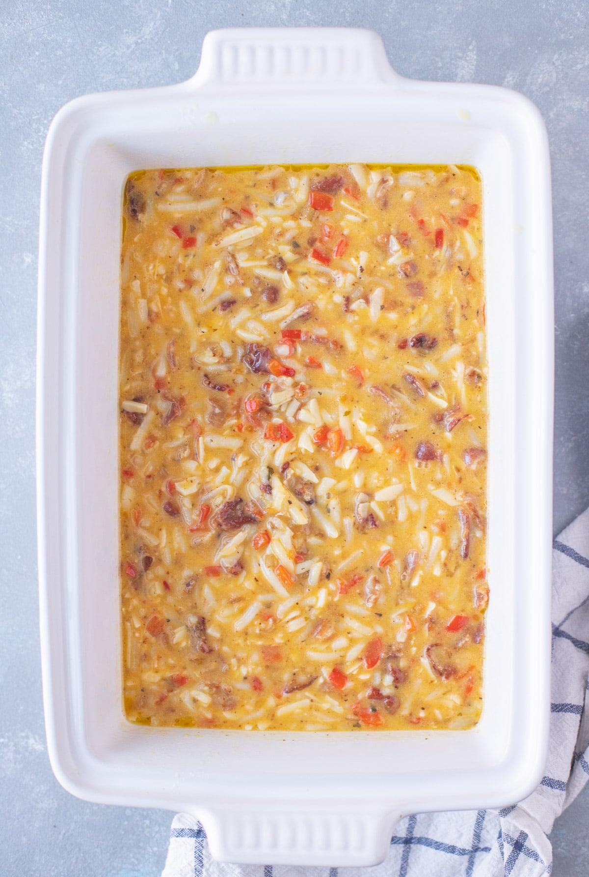 Unbaked egg bake in a white casserole dish.