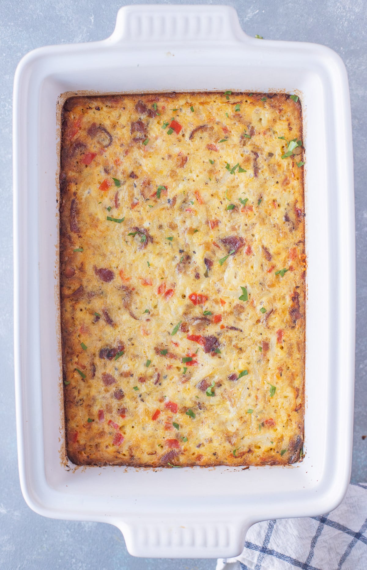 Fully baked egg casserole with bacon, hashbrowns, vegetables, and cheese.