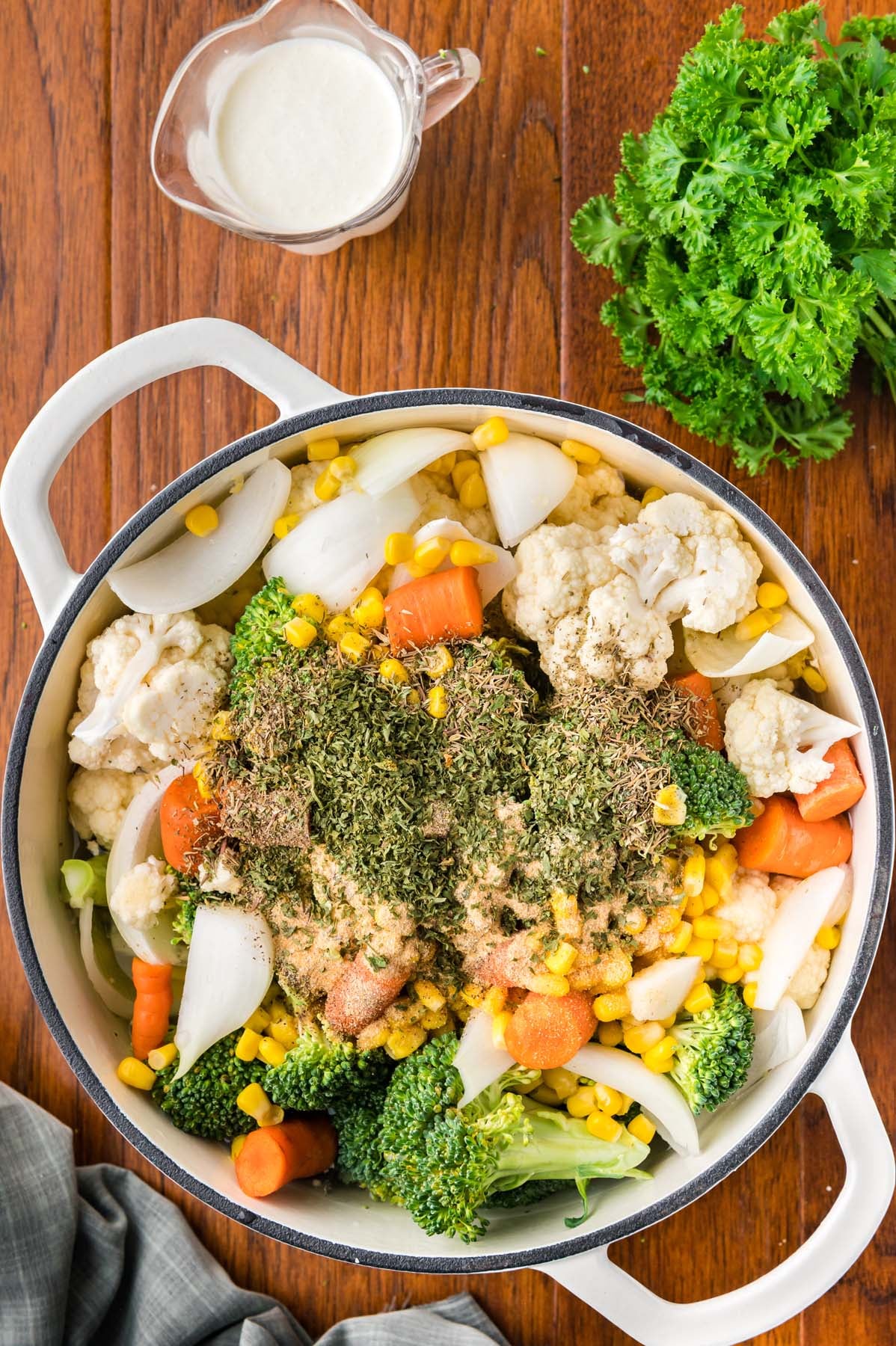 A dutch oven filled with veggies and ingredients for creamy vegetable soup before cooking