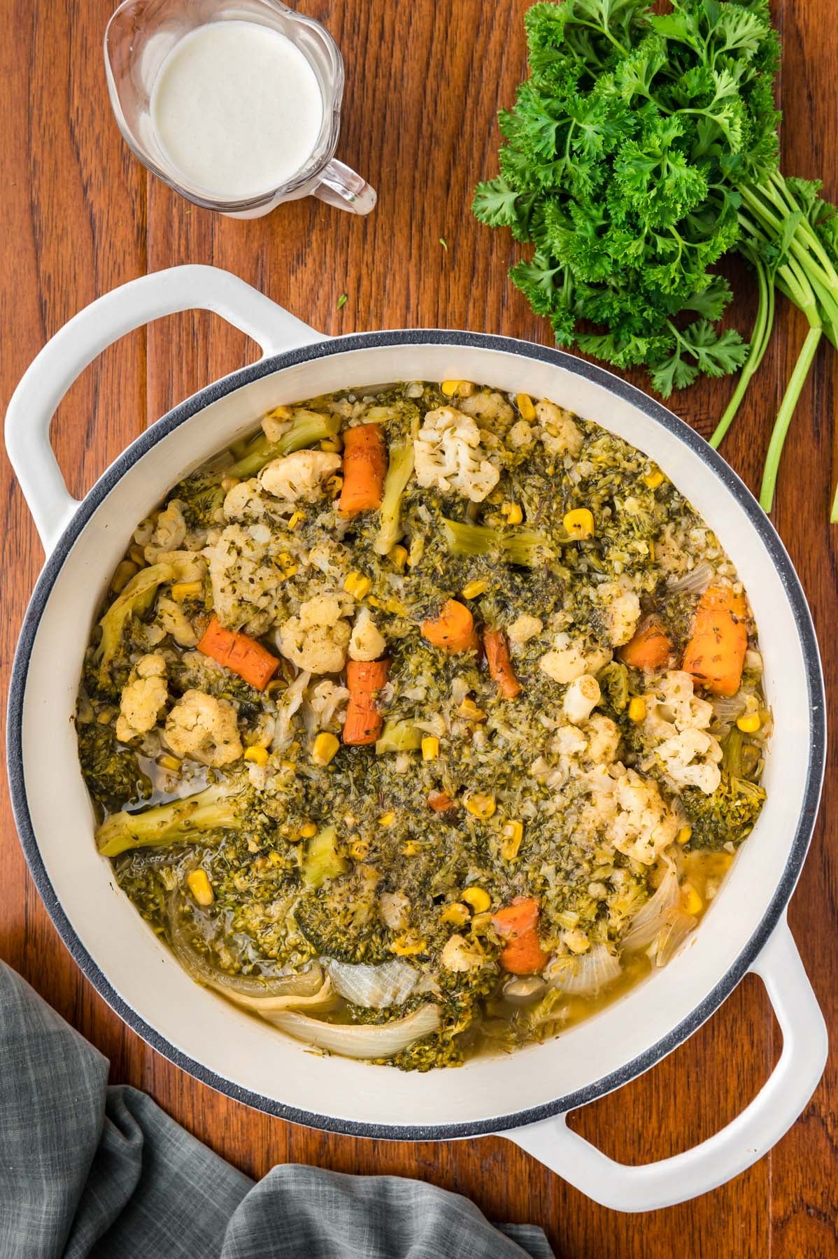 A dutch oven filled with veggies and ingredients for creamy vegetable soup after cooking but before blending
