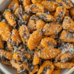 An overhead shot of sweet potato gnocchi on a grey background