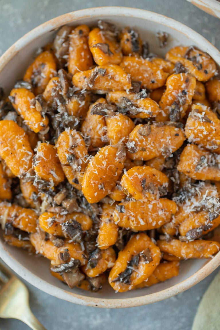 An overhead shot of sweet potato gnocchi on a grey background